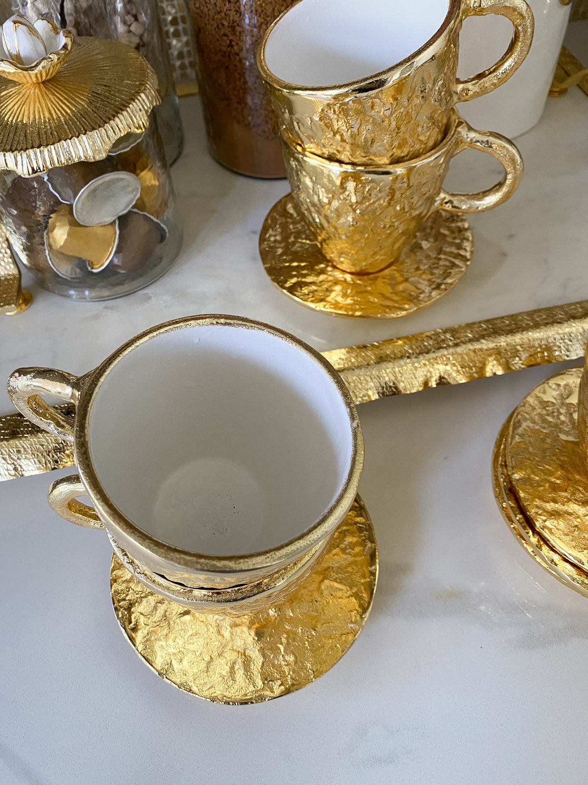 https://www.shopinspiremehomedecor.shop/wp-content/uploads/1693/26/gold-textured-metal-tea-cup-and-saucer-with-white-interior-inspire-me-home-decor-explore-a-world-of-possibilities-take-a-look-at-our-extensive-selection_3.jpg